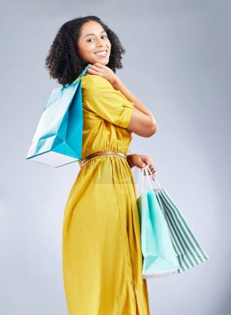 Photo for Shopping bag, fashion and young woman for happy discount, sale and retail promotion on a white background. Winning gift, giveaway and customer, model or african person in clothes portrait and studio. - Royalty Free Image