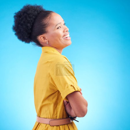 Photo for Happy, laughing and a black woman in studio with funny humor, confidence and a positive mindset. Fashion, arms crossed and profile of a female model person in casual clothes on a blue background. - Royalty Free Image