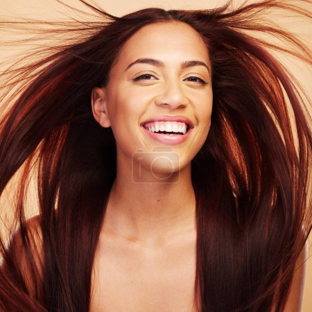 Photo for Wind, beauty or portrait of happy woman with hair care after salon treatment isolated on brown background. Natural glow, breeze and face of proud model with cosmetics, smile or hairstyle in studio. - Royalty Free Image