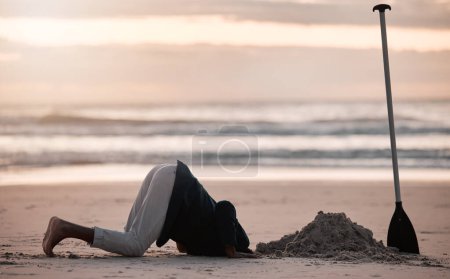 Photo for Digging hole, search and a man on the beach for a vacation, treasure hunt or check underground. Nature, travel and a person with a shovel at the ocean during sunset or sunrise and playing in the sand. - Royalty Free Image