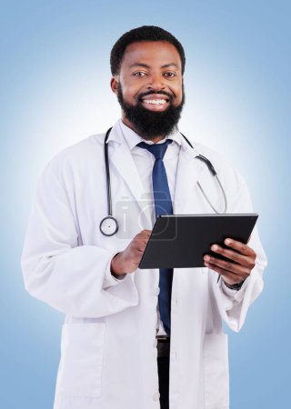Photo for Healthcare, portrait and tablet and a black man doctor in studio on a blue background for cardiology research. Medical, innovation and a male medicine professional searching for information online. - Royalty Free Image