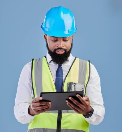 Photo for Black man, architect and tablet for construction inspection or planning against a blue studio background. African male person, engineer or contractor working on technology for industrial architecture. - Royalty Free Image