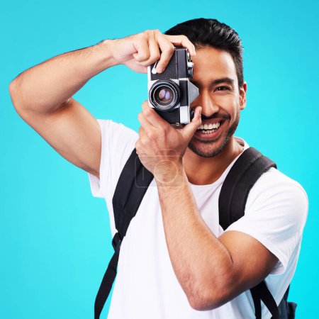 Photo for Portrait, smile and man with a camera, photography and taking picture against a blue studio background. Face, male person or model with creativity, vintage technology or photographer with inspiration. - Royalty Free Image