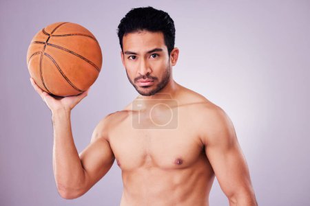 Photo for Portrait, basketball and focus with a sports man in studio on a gray background for training or a game. Fitness, body or shirtless and a young male athlete holding a ball with focus or confidence. - Royalty Free Image