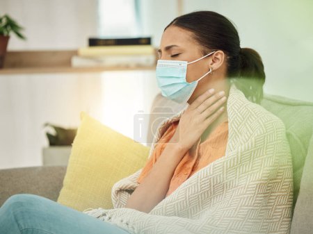 Photo for Sick, virus and face mask with woman on sofa for sore throat, illness and inflammation. Allergy, tired and fever with female patient in living room at home for pneumonia, disease and fatigue. - Royalty Free Image