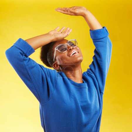 Photo for Fashion, freedom and fun with a black woman on a yellow background in studio for trendy gen z style. Relax, smile and excited with a happy young girl indoor to dance with a carefree expression. - Royalty Free Image
