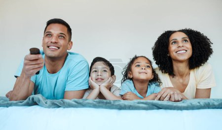 Photo for Mom, dad and children on bed, watching tv and smile for comedy, funny movie or cartoon in family house. Happy parents, kids and watch television show with streaming, subscription and relax together. - Royalty Free Image