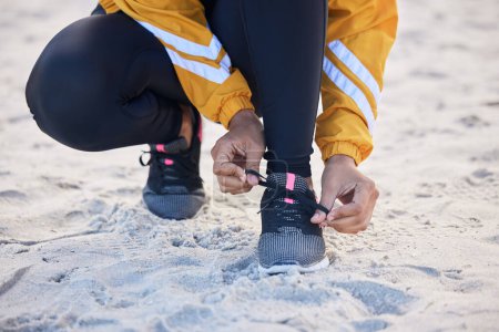 Photo for Beach, closeup and woman tie shoes for an outdoor run for fitness, health and wellness by seaside. Sports, athlete and zoom of female runner tying laces for a cardio workout or exercise by the ocean - Royalty Free Image
