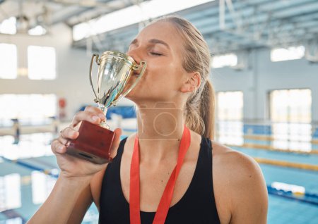 Photo for Trophy kiss, win and a woman with swimming achievement, competition pride and happiness. Celebration, pool and a professional swimmer with an award or prize for training, sport or water fitness. - Royalty Free Image