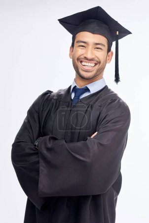Foto de Estudiante, brazos cruzados y graduación en retrato de estudio, sonrisa y éxito por fondo blanco. Joven, feliz graduado universitario y logro de la educación con orgullo, metas y celebración. - Imagen libre de derechos