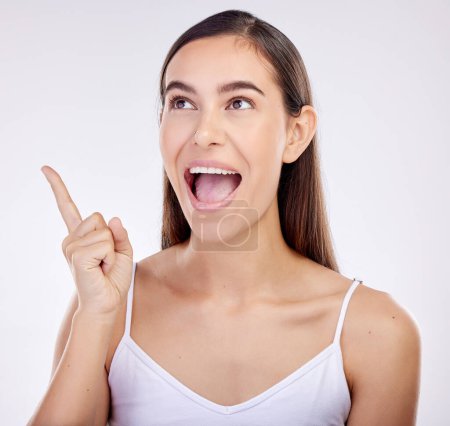 Photo for Pointing, surprise and woman excited, announcement and happiness on a white studio background. Wow face, person or model with shock, hand sign and choice with ideas, promotion and news with promotion. - Royalty Free Image