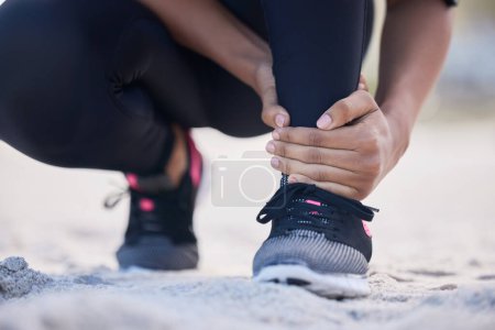 Photo for Fitness, ankle pain and running with woman on beach for sports injury, inflammation and accident. Emergency, healthcare and muscle with closeup of runner for exercise, physical therapy and workout. - Royalty Free Image