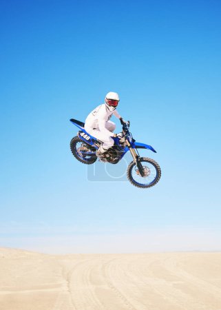 Photo for Jump, motorbike and person in desert, blue sky with action and extreme sport, speed outdoor and mockup space. Adventure, fitness and motorcycle in air with stunt performance, freedom and challenge. - Royalty Free Image