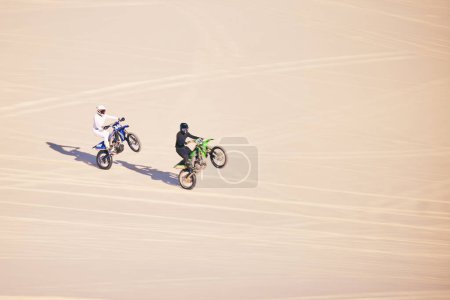 Photo for Motorcycle, sand and sports with people in the desert for adrenaline, adventure or training in nature. Bike, summer and freedom with friends outdoor together to wheelie while riding on mockup space. - Royalty Free Image