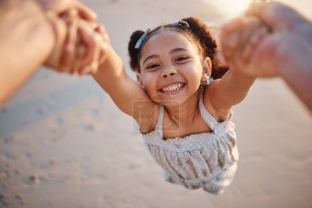 Photo for Girl child, swing and pov at beach, portrait and smile for game, holding hands or speed in summer. Young female kid, parent and spin in air, sand or happy for family bonding, love or care in sunshine. - Royalty Free Image