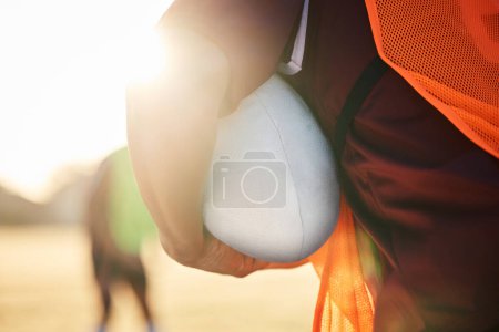 Photo for Rugby, sports and hands on ball in exercise, workout or training outdoor at field lens flare. American football, fitness and man ready to start practice in game, competition or match for body health. - Royalty Free Image