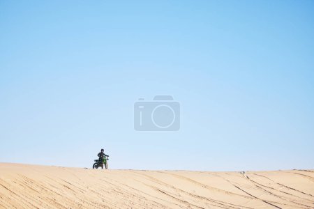 Téléchargez les photos : Course de moto, désert et sable avec espace, fond bleu ciel et extérieur pour défi hors route en été. Moto, personne et sentier de terre pour la performance, la puissance et l'aventure rapide pour la maquette. - en image libre de droit