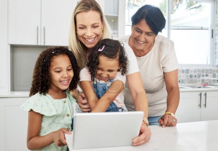 Blended family, adoption and a girl with her mother on a tablet in the kitchen for education or learning. Children, diversity or study with a parent and granny teaching girl kids at home together.
