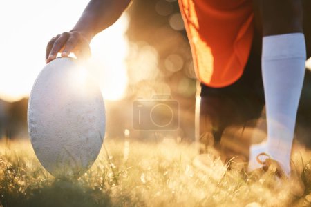 Foto de Rugby, primer plano de pelota y sol, deportes en el campo al aire libre con bokeh, objetivo con fitness y tren para el partido. Ejercicio, persona atleta mano y juego con práctica, salud y activo con el jugador y listo. - Imagen libre de derechos