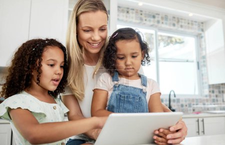 Blended family, adoption and a mother with her kids on a tablet in the kitchen for education or learning. Sister, diversity and study with woman teaching her girl daughters in their home together.