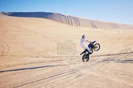 Photo for Bike, sports and space with a man in the desert for adrenaline, adventure or training in nature. Moto, fitness and freedom with an athlete riding a motorcycle for energy or balance on sand in Dubai. - Royalty Free Image