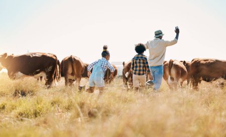 Foto de Animales, padres e hijos en granja familiar al aire libre con ganado, sostenibilidad y ganado. Detrás del hombre africano y los niños caminando en un campo para la aventura del agricultor o vacaciones en el campo con vacas. - Imagen libre de derechos