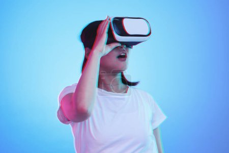 Mujer, VR y visión con wow para la experiencia futurista, juegos 3D y educación general z o aprendizaje digital e. Estudiante con sorpresa para realidad virtual, alta tecnología y gafas en fondo de estudio azul.