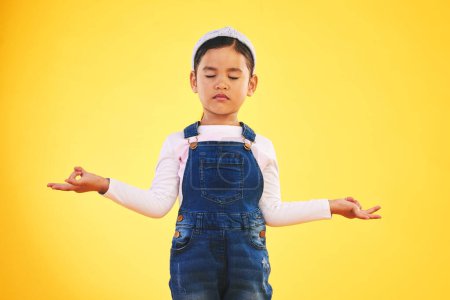Photo for Lotus, hands and girl child with meditation in studio for wellness, peace or balance on yellow background. Children, mental health and kid with yoga pose for energy training or holistic exercise. - Royalty Free Image