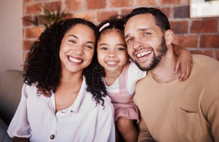 Photo for Family, happy and portrait with a hug on a home sofa for fun, bonding and time together. A man, woman or parents and girl kid in a lounge with love, care and happiness in a house in Puerto Rico. - Royalty Free Image