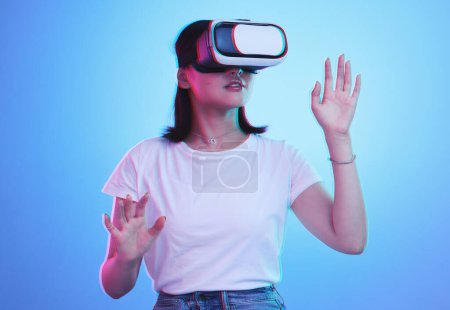 Foto de Gafas, realidad virtual y mujer en metaverso futurista, juegos 3d en educación o aprendizaje digital e. Joven o estudiante en VR, alta tecnología o visión con fondo de neón y azul, estudio. - Imagen libre de derechos