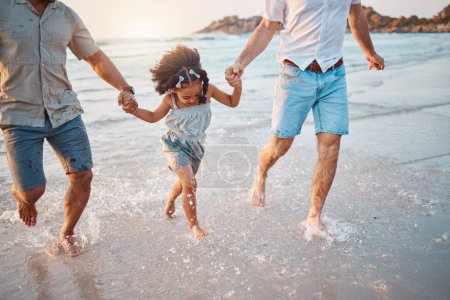 Photo for Beach, running and parents holding hands with girl in water on holiday, vacation and adventure. Lgbtq family, summer and happy child with fathers by ocean for bonding, relationship and fun outdoors. - Royalty Free Image