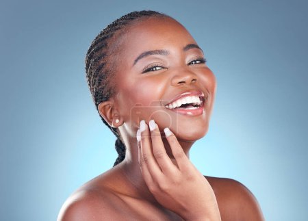 Téléchargez les photos : Portrait de femme noire pour soins de la peau, cosmétiques et sourire sur fond bleu pour le bien-être, la santé et le spa. Soins du visage, dermatologie et visage de la personne africaine en studio avec beauté, maquillage et éclat. - en image libre de droit