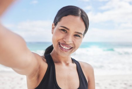 Téléchargez les photos : Femme heureuse, portrait et fitness sur la plage pour selfie, photographie ou post sur les réseaux sociaux en plein air. Femme sourire pour l'image, photo ou mémoire dans l'entraînement, l'exercice ou la course sur la côte de l'océan. - en image libre de droit