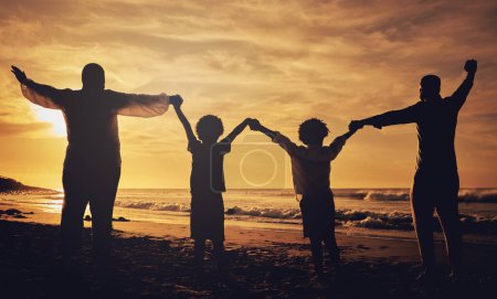 Foto de De la mano, puesta de sol y silueta de una familia en la playa con amor, libertad y felicidad. Verano, viaje y vuelta de padres con hijos, afecto y juntos en la oscuridad junto al océano. - Imagen libre de derechos