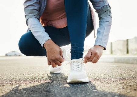 Photo for Fitness, closeup and woman tie shoes outdoor in the road for running workout in the city. Sports, health and zoom of female athlete tying her laces for cardio exercise for race or marathon training - Royalty Free Image