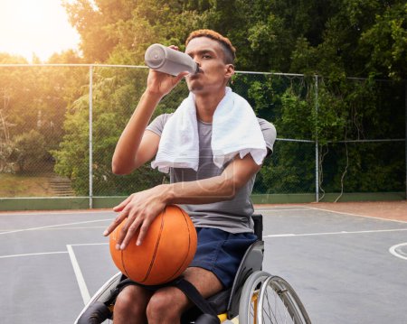 Téléchargez les photos : Joueur de basket-ball, eau potable ou homme en fauteuil roulant pour la pause sportive, repos ou électrolytes de remise en forme sur le terrain. Personne handicapée, athlète ou bouteille pour la récupération, l'exercice et le bien-être d'entraînement. - en image libre de droit