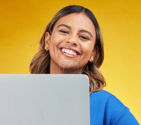 Photo for Smile, laptop and portrait of woman on yellow background, networking and online influencer with internet connection. Computer, studio and face of happy content creator with social media, email or web. - Royalty Free Image