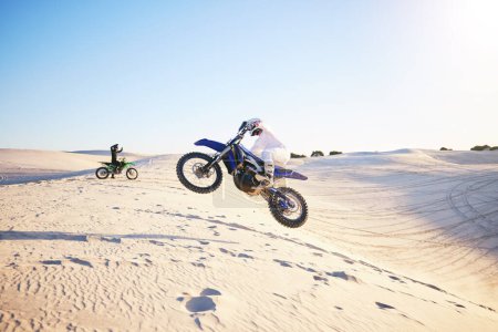 Photo for Motorcycle, desert race and jump in air for competition, stunt and outdoor for performance, goal and speed. Motorbike athlete, dunes and ramp in nature, sand and together for training in mockup space. - Royalty Free Image