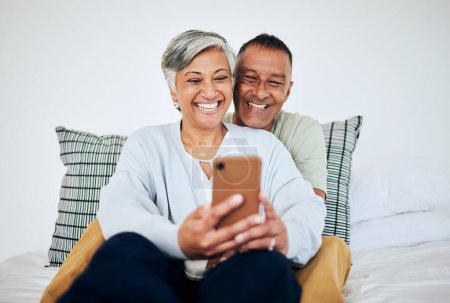 Photo for Mature, couple and selfie in bed at home with smile, retirement love and happy marriage. House, mobile and social media for profile picture in bedroom relax and online together and photo on web. - Royalty Free Image