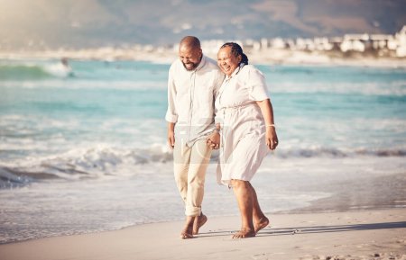 Foto de El amor, la celebración de la mano y la tercera edad con la pareja negra en la playa y reír en la jubilación, vacaciones y vacaciones de verano. Viaje, sonrisa y y vinculación con el hombre y la mujer caminando por feliz, divertido y relajarse. - Imagen libre de derechos