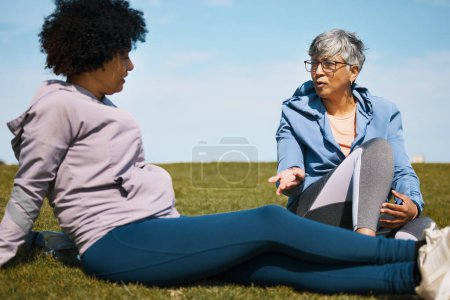 Photo for Talking, fitness and senior women friends on the grass outdoor taking a break from their workout routine. Exercise, training and summer with elderly people in conversation on a field for wellness. - Royalty Free Image