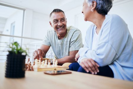 Photo for Senior couple, playing chess and happy for thinking, strategy or mindset with excited smile, relax or bonding. Elderly woman, man and sofa for board game, idea or moving for win, challenge and home. - Royalty Free Image