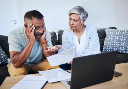 Photo for Frustrated senior couple, documents and laptop in debt, financial crisis or struggle on sofa at home. Upset elderly man and woman in disagreement, argument or fight with finance, bills or expenses. - Royalty Free Image