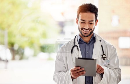Photo for Asian man, doctor and tablet with smile in hospital for planning, research and consulting on blurred background. Clinic, schedule and Japanese male health expert on app for Telehealth, help or advice. - Royalty Free Image