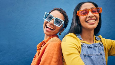 Photo for Sunglasses, fashion and portrait of friends on blue background with trendy clothes, accessories and style. City, summer clothes and face of happy women with smile on holiday, vacation and weekend. - Royalty Free Image