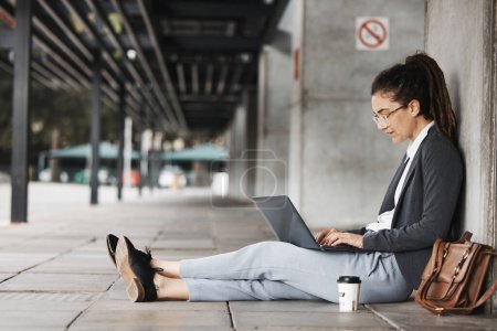 Photo for Typing, laptop and woman on a coffee break in the city or employee on social media, job search or online hiring opportunity. Unemployed, worker and networking on computer in town for business. - Royalty Free Image
