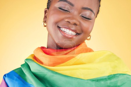 Foto de Mujer lesbiana africana, bandera de orgullo y estudio con sonrisa, pensamiento o inclusión para la libertad gay por fondo amarillo. Estudiante chica, tela arco iris o tela para votar, igualdad o feliz para el icono lgbtq. - Imagen libre de derechos