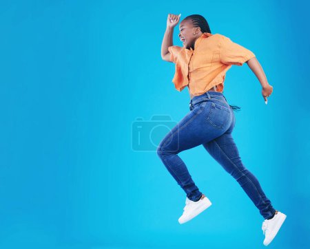 Photo for Jump, black woman and excited with motivation in studio from celebration and smile. Happy, energy and African female person with mockup space and blue background with leap from deal and announcement. - Royalty Free Image