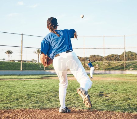 Photo for Baseball, pitching and a sports person outdoor on a pitch for performance or competition. Behind professional athlete or softball player with fitness, ball and throw for game, training or exercise. - Royalty Free Image