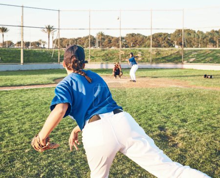 Photo for Pitching, baseball and a sports person outdoor on a pitch for performance or competition. Behind professional athlete or softball player for throw, fitness and team for a game, training or exercise. - Royalty Free Image